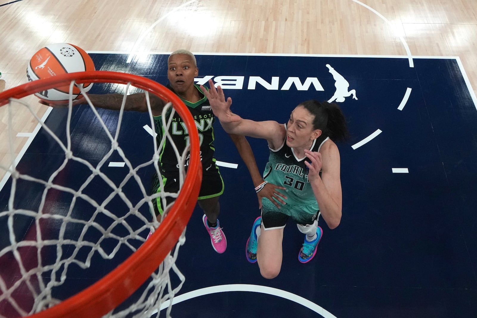 Minnesota Lynx guard Courtney Williams, left, goes up to shoot as New York Liberty forward Breanna Stewart (30) defends during the first half of Game 4 of a WNBA basketball final playoff series, Friday, Oct. 18, 2024, in Minneapolis. (AP Photo/Abbie Parr)