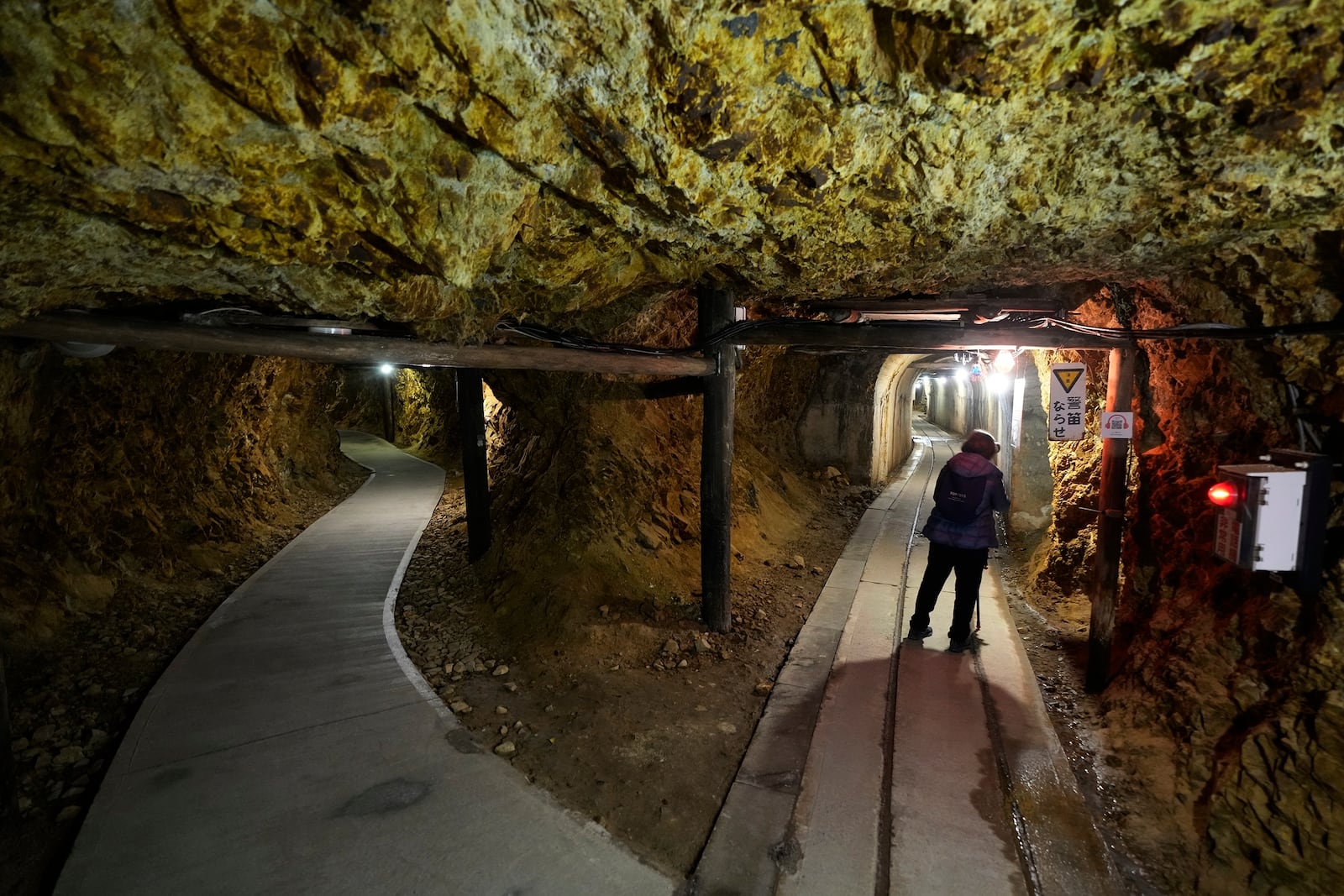 A visitor walk through tunnels at Sado Kinzan Gold Mine historic site in Sado, Niigata prefecture, Japan, Sunday, Nov. 24, 2024. (AP Photo/Eugene Hoshiko)