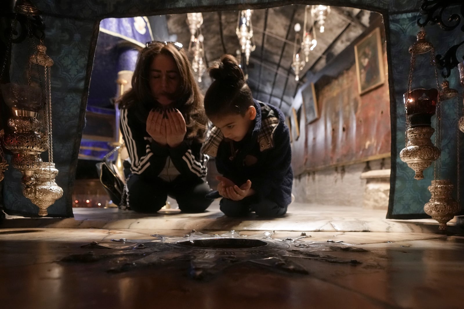 Worshippers pray in the Church of the Nativity, where Christians believe Jesus Christ was born, ahead of Christmas in the West Bank city of Bethlehem, Tuesday, Dec. 17, 2024. (AP Photo/Mahmoud Illean)