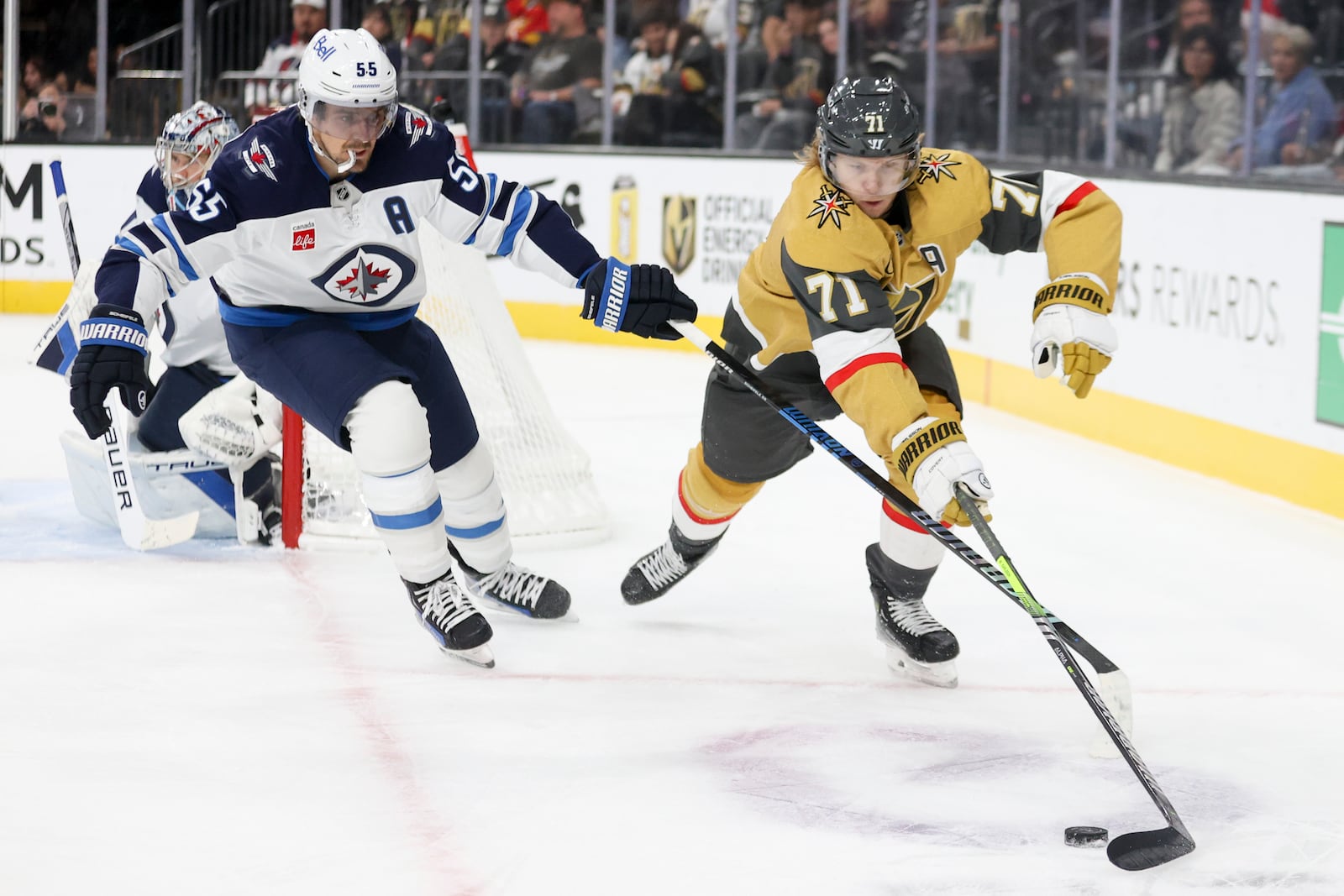 Vegas Golden Knights center William Karlsson (71) skates past Winnipeg Jets center Mark Scheifele (55) during the second period of an NHL hockey game Friday, Nov. 29, 2024, in Las Vegas. (AP Photo/Ian Maule)