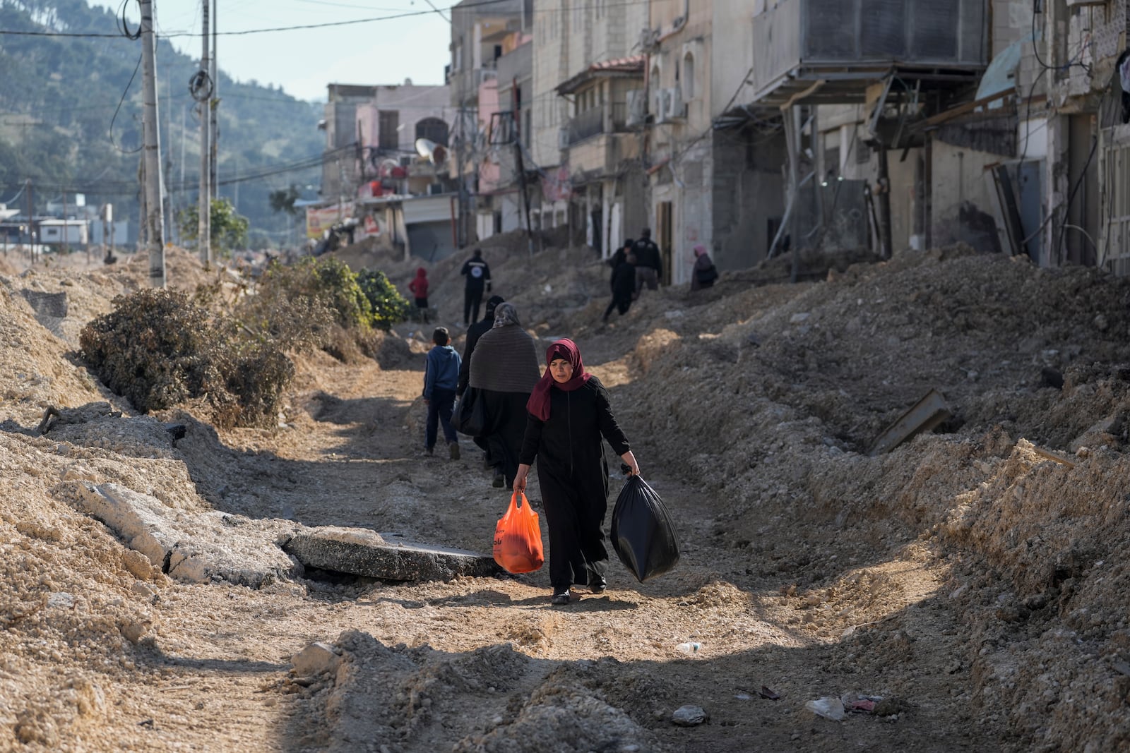 Residents of the West Bank urban refugee camp of Nur Shams evacuate their homes and carry their belongings as the Israeli military continues its operation in the area on Wednesday, Feb. 26, 2025. (AP Photo/Majdi Mohammed)