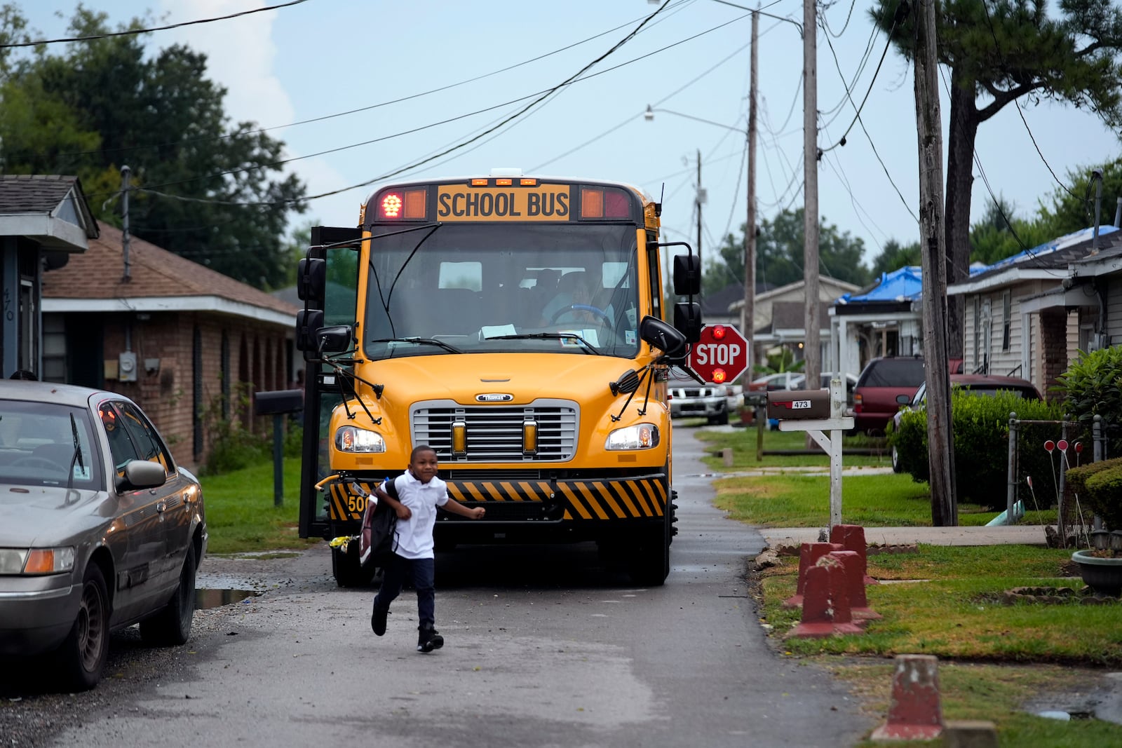 DeAnthony Nabor, 6, runs home from the school bus in the Elkinsville section of St. Rose, La., Friday, Aug. 16, 2024. (AP Photo/Gerald Herbert)