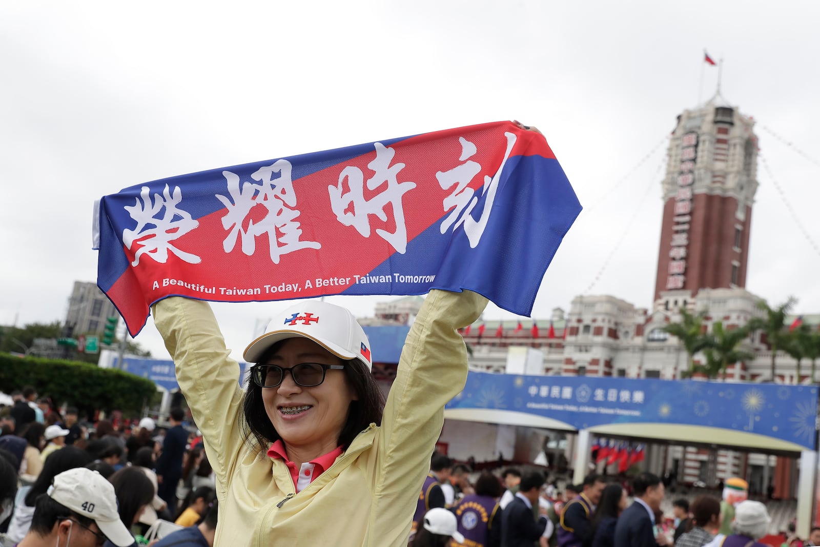 A person poses with a slogan reading "Honor Time" for a photo during National Day celebrations in front of the Presidential Building in Taipei, Taiwan, Thursday, Oct. 10, 2024. (AP Photo/Chiang Ying-ying)