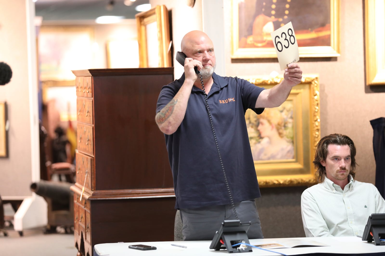 A Brunk auction employee waits to see if a bidder on the phone wants to make a bid during an auction that included a 1787 copy of the U.S. Constitution that sold for $9 million at Brunk Auctions in Asheville, N.C., on Thursday, Oct. 17, 2024. (AP Photo/Jeffrey Collins)