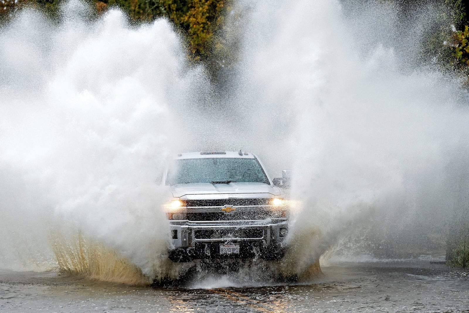 A pick-up truck drives through floodwaters as heavy rains fall in Windsor, Calif., on Friday, Nov. 22, 2024. (AP Photo/Noah Berger)