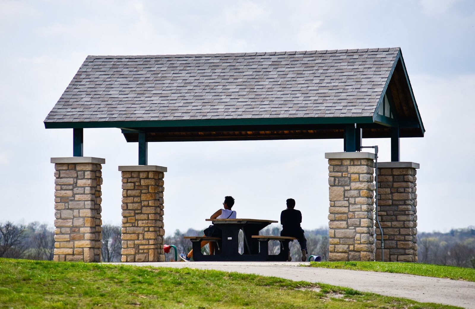 Two people take a break in April while at Huffman Park in Fairfield. NICK GRAHAM/STAFF