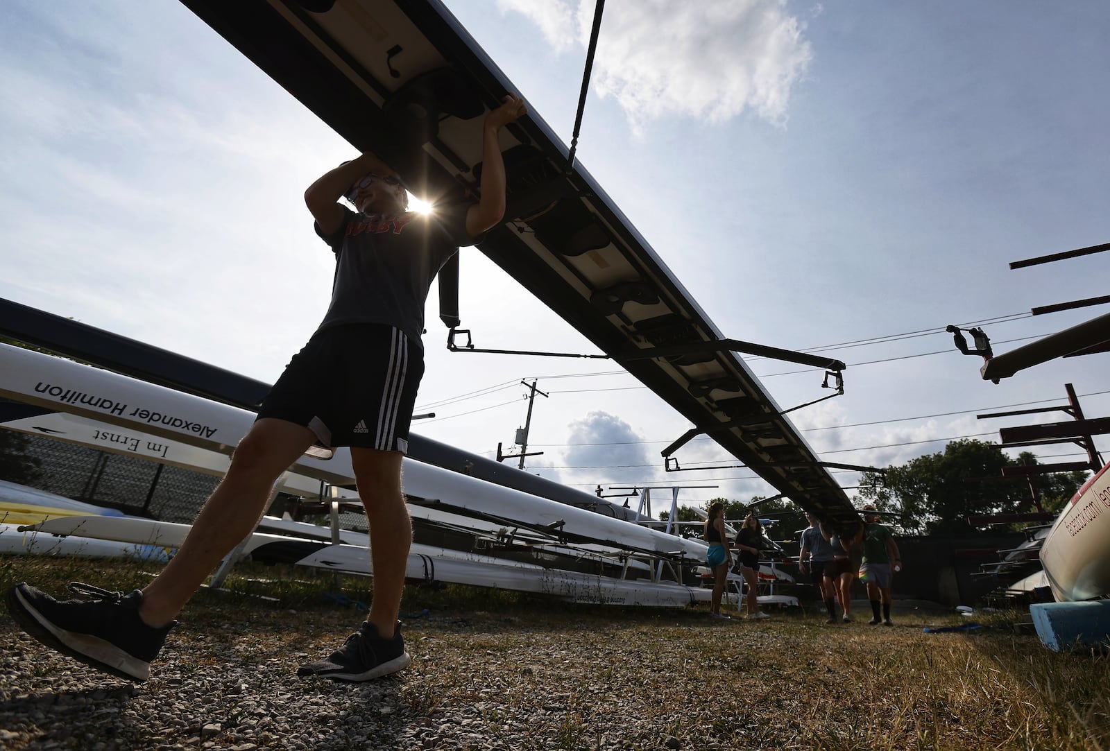 Great Miami Crew rowing team members get boats ready during practice Wednesday, Aug. 11, 2021 on the Great Miami River in Hamilton. NICK GRAHAM / STAFF