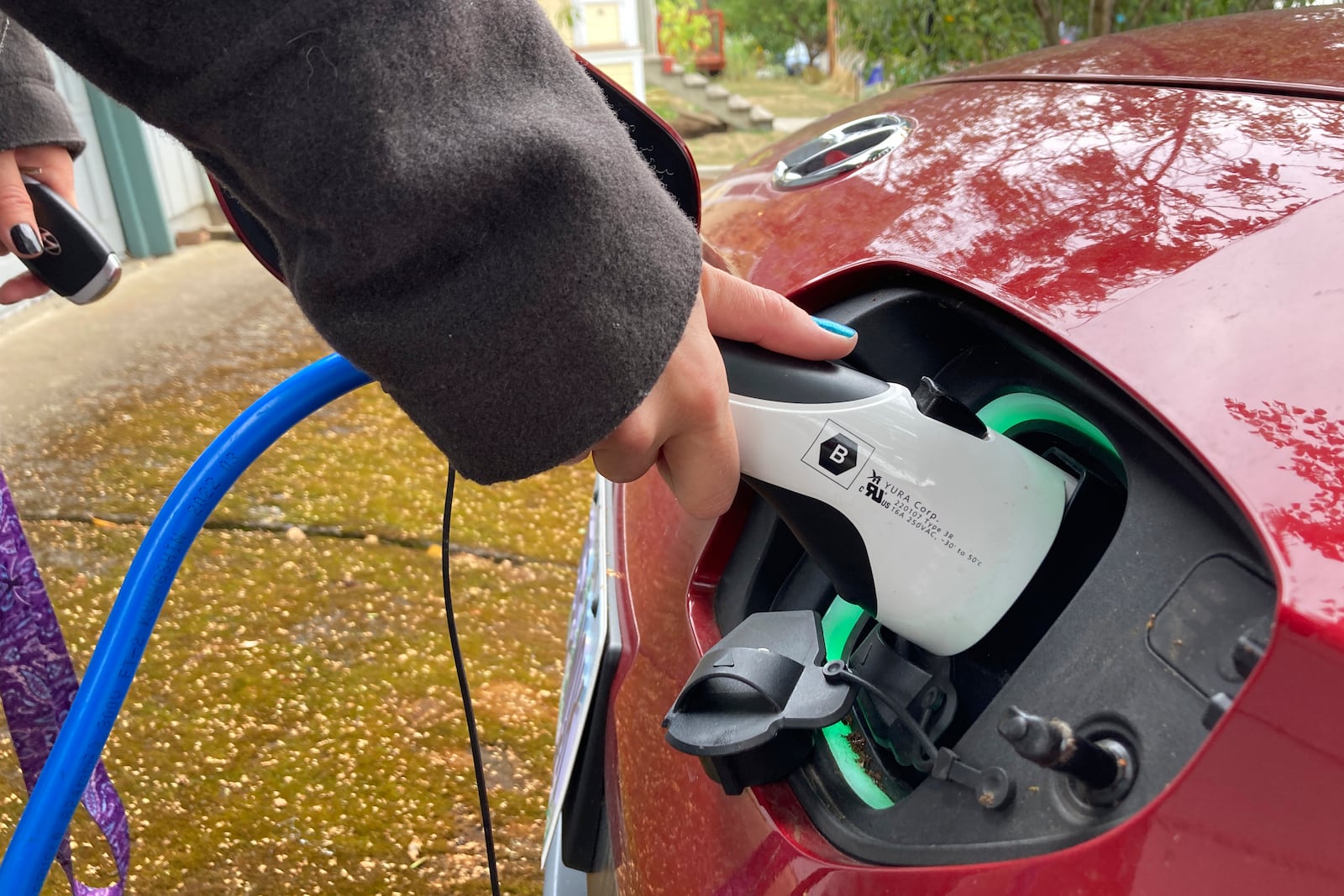 FILE - Rebecca DeWhitt charges her electric vehicle in the driveway of the Portland, Ore., home she rents on Sept. 30, 2022. (AP Photo/Gillian Flaccus, File)