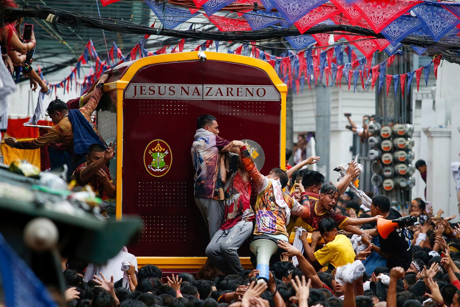 Devotees try to climb on a glass-covered carriage carrying the image of Jesus Nazareno during its annual procession in Manila, Philippines Thursday, Jan. 9, 2025. (AP Photo/Basilio Sepe)