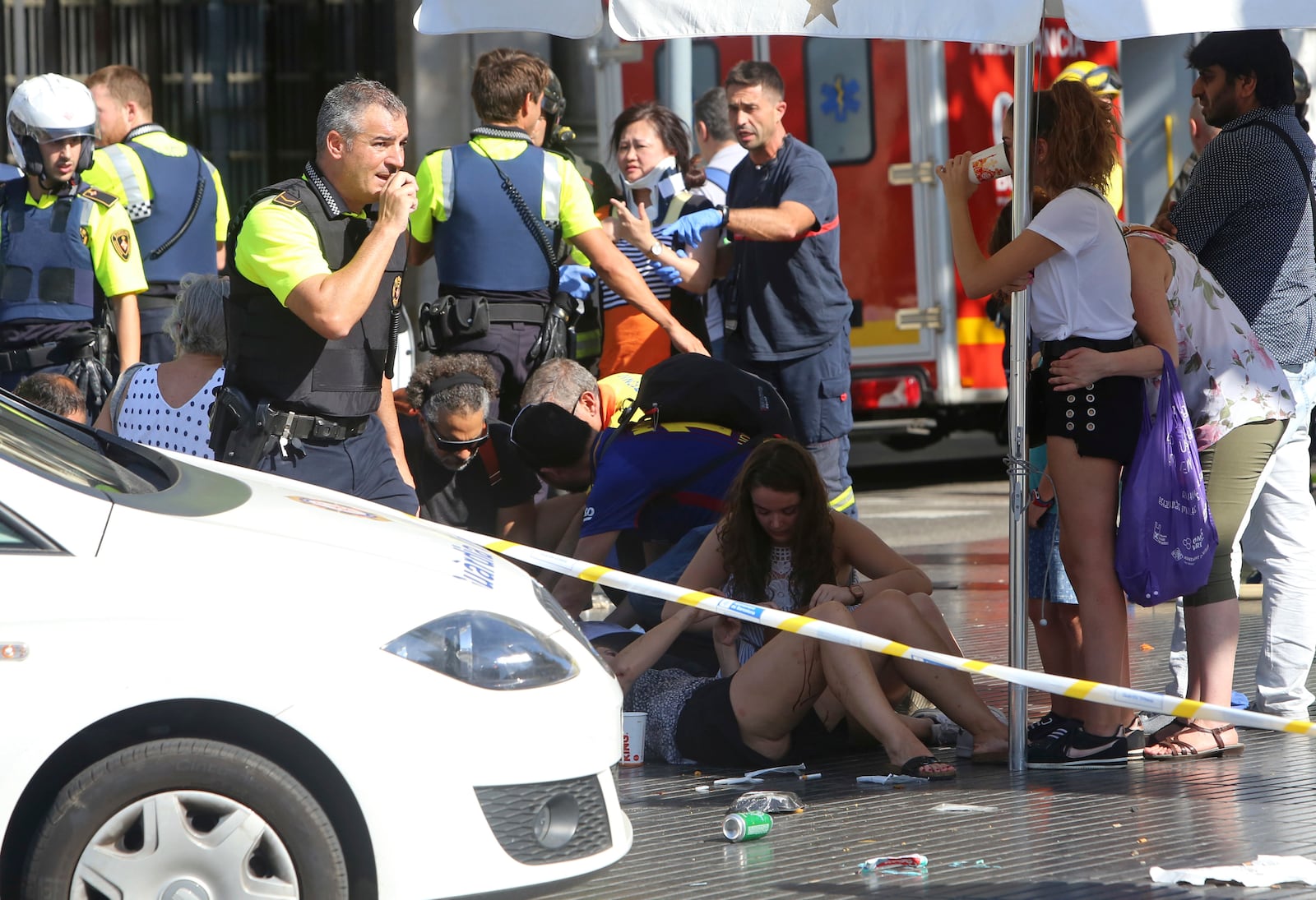 FILE - Injured people are treated in Barcelona, Spain, Thursday, Aug. 17, 2017 after a white van jumped the sidewalk in the historic Las Ramblas district, crashing into a summer crowd of residents and tourists. (AP Photo/Oriol Duran, File)