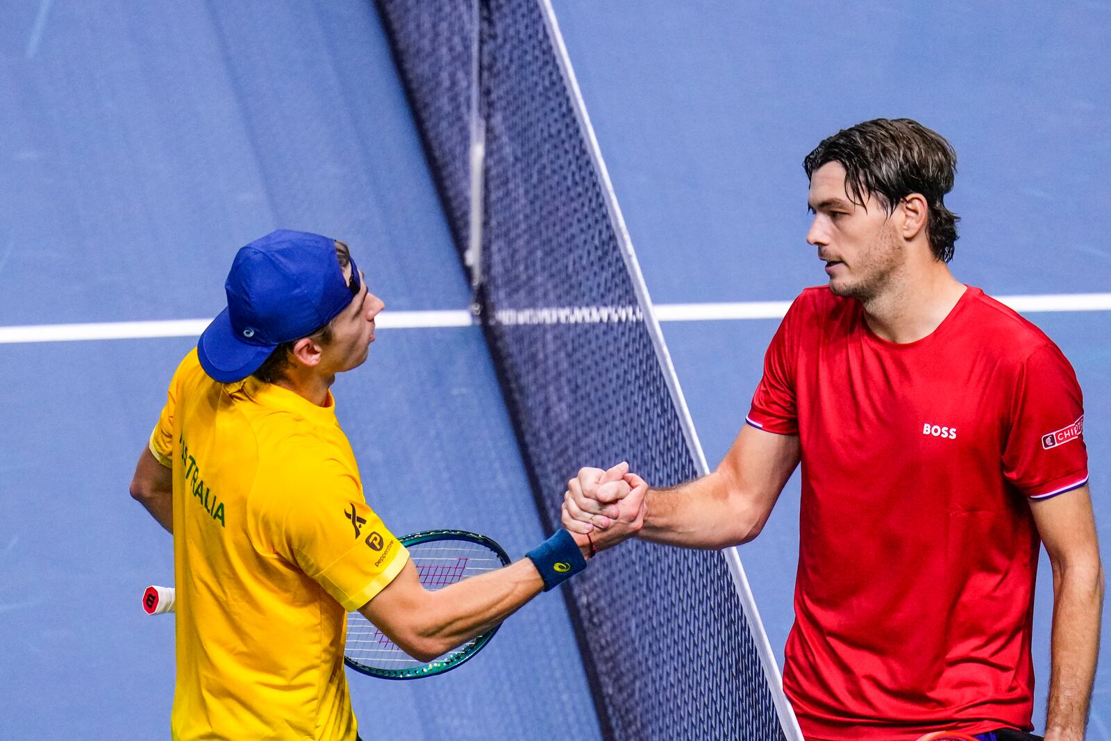 Taylor Fritz of the United States, right, shakes hands afer defeating Australia's Alex de Minaur during a Davis Cup quarterfinal match at the Martin Carpena Sports Hall, in Malaga, southern Spain, on Thursday, Nov. 21, 2024. (AP Photo/Manu Fernandez)