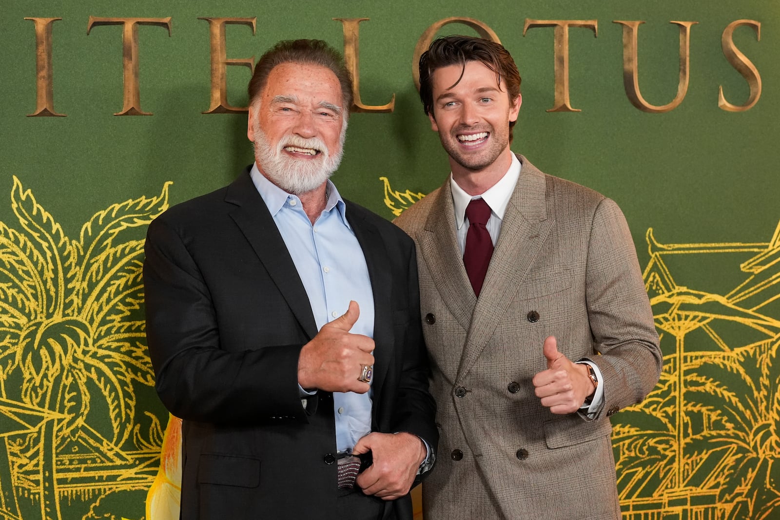 Arnold Schwarzenegger, left, and Patrick Schwarzenegger give the thumbs up at the season three premiere of "The White Lotus" on Monday, Feb. 10, 2025, at Paramount Theater in Los Angeles. (AP Photo/Chris Pizzello)