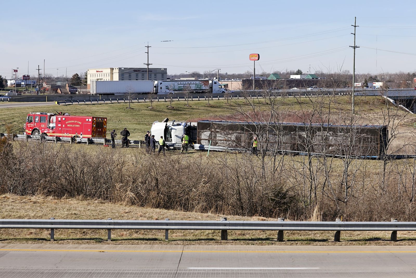 A semi hauling crushed cars rolled over on its side on the ramp from eastbound Ohio 122 to I-75 northbound in Middletown. NICK GRAHAM / STAFF