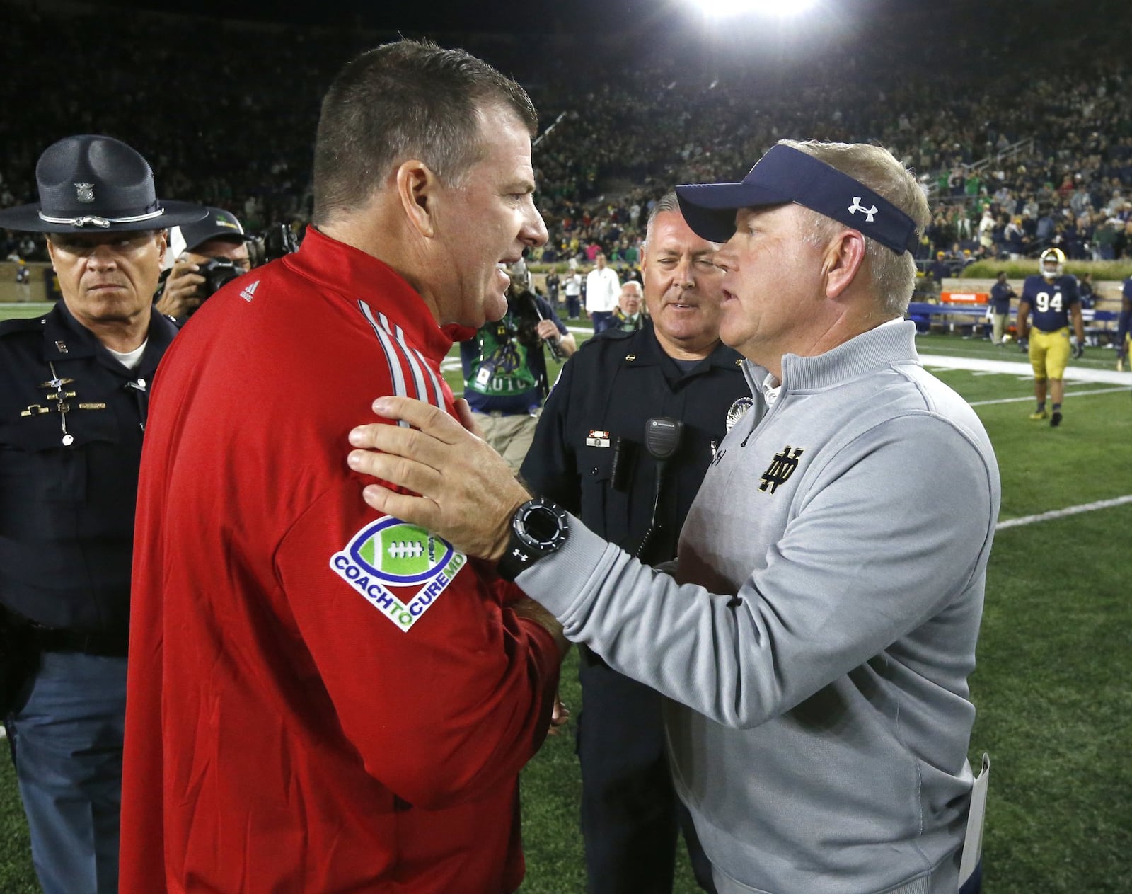 Miami coach Chuck Martin (left) and Notre Dame coach Brian Kelly meet on the field Saturday night after Kelly’s Fighting Irish recorded a 52-17 triumph at Notre Dame Stadium in Notre Dame, Ind. CHARLES REX ARBOGAST/ASSOCIATED PRESS