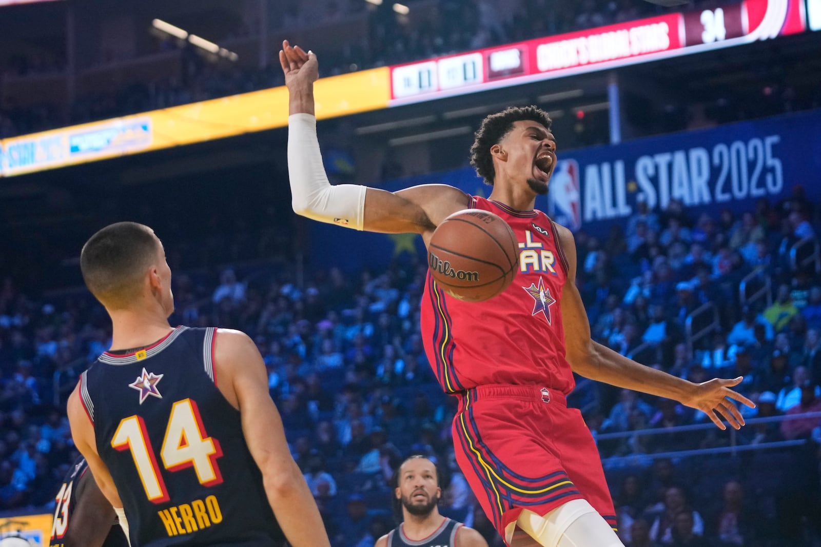 San Antonio Spurs center Victor Wembanyama dunks past Miami Heat guard Tyler Herro during the NBA All-Star basketball game Sunday, Feb. 16, 2025, in San Francisco. (AP Photo/Godofredo A. Vásquez)