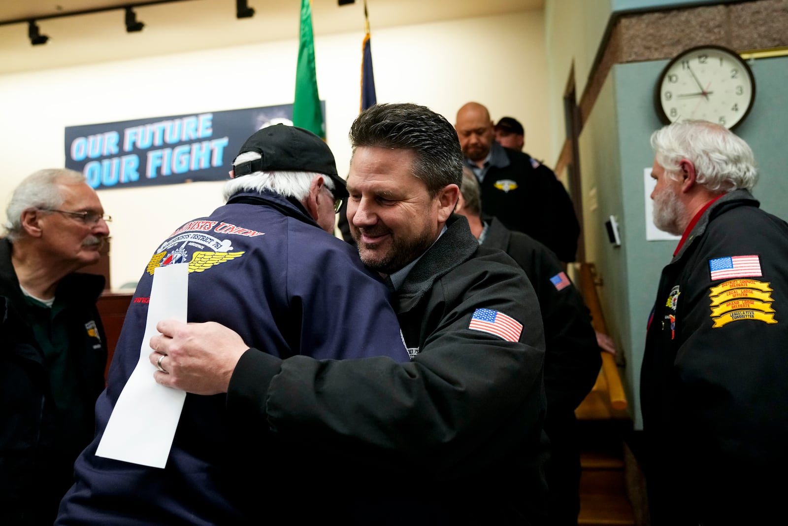 Eep Bolaño listens as IAM District 751 president Jon Holden greets union members after announcing they voted to accept a new contract offer from Boeing, Monday, Nov. 4, 2024, at their union hall in Seattle. (AP Photo/Lindsey Wasson)