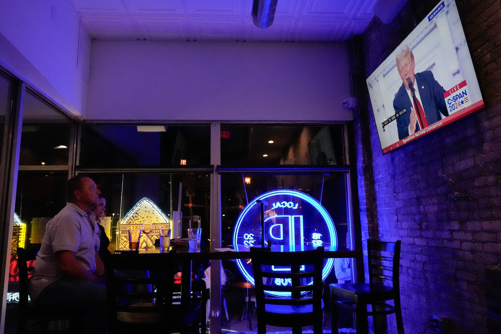 FILE - Jim, left, and Tamara Hamilton watch former President Donald Trump speak on television on Thursday, July 18, 2024, in Milwaukee. (AP Photo/Mike Stewart, File)