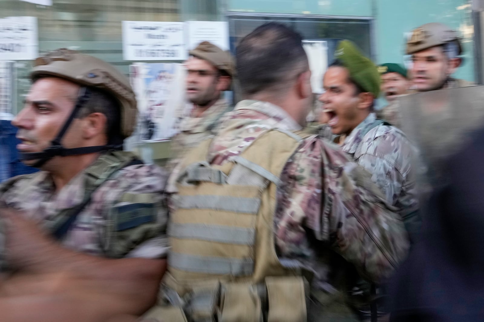 People displaced by Israel's war on Hezbollah scuffle with members of the Lebanese security, after dozens of policemen arrived at the building to evict the displaced from the private property, in Beirut, Lebanon, Monday, Oct. 21, 2024. (AP Photo/Hassan Ammar)