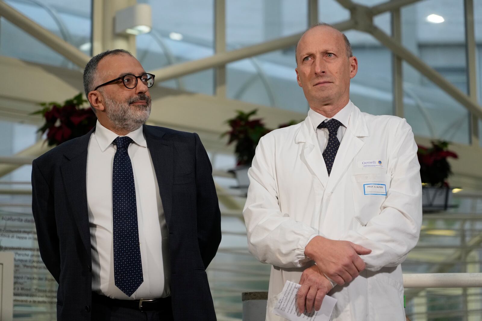 From left, head physician of Vatican's Health and Hygiene Office, Luigi Carbone, and Surgeon Sergio Alfieri, speak to journalists, Saturday, March 22, 2025, in the entrance hall of Rome's Agostino Gemelli Polyclinic where Pope Francis is being treated for bilateral pneumonia since Feb. 14, 2025. (AP Photo/Gregorio Borgia)