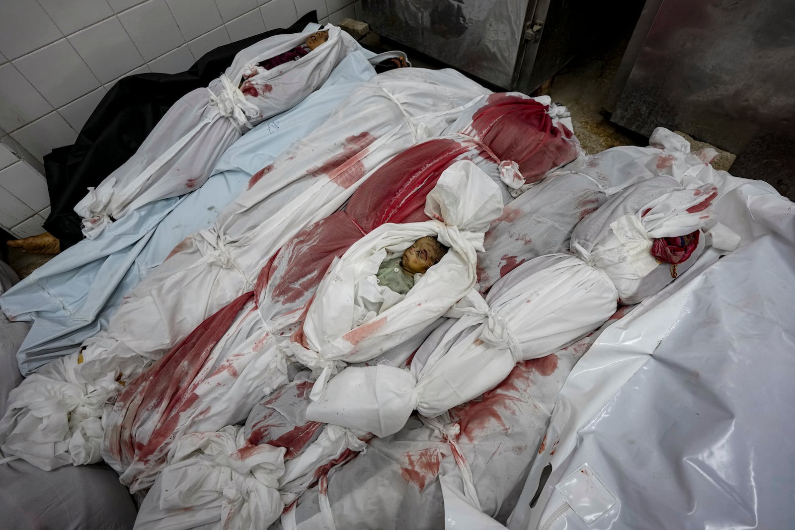 EDS NOTE: GRAPHIC CONTENT - Bodies of Palestinians killed in the Israeli bombardment of the Gaza Strip are seen at a hospital morgue in Deir al-Balah, Friday, Nov. 1, 2024. (AP Photo/Abdel Kareem Hana)