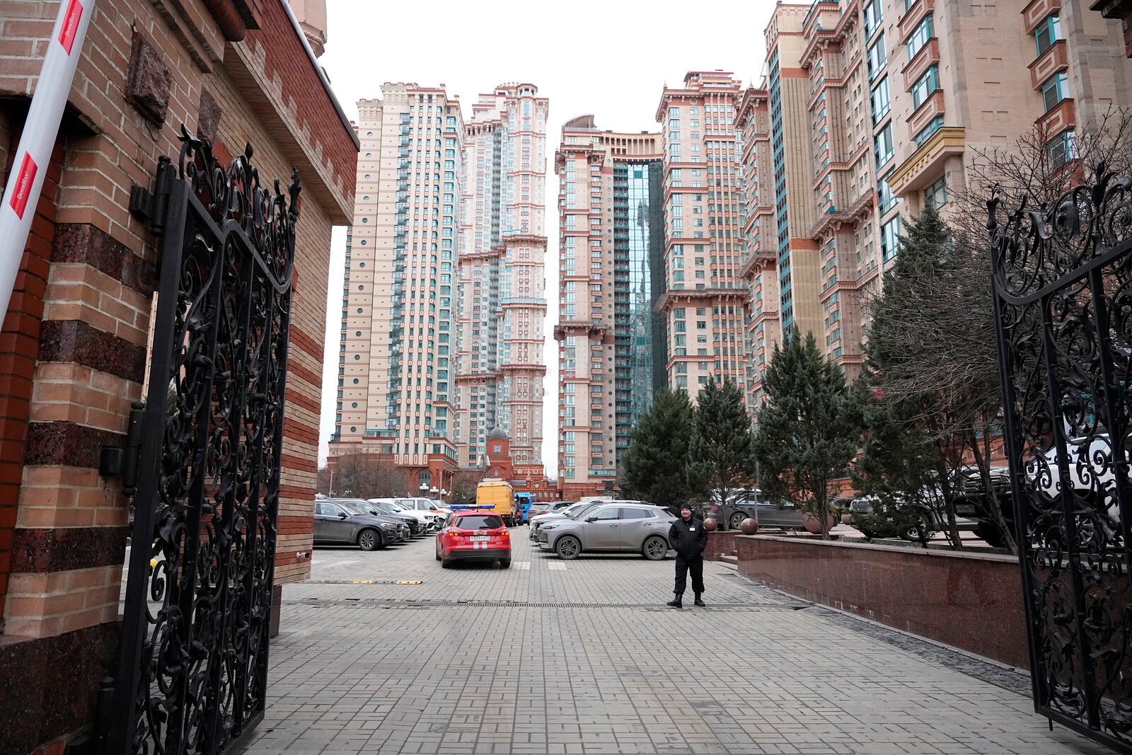 A security man stands in the yard of an upscale residential block in Moscow, Russia, Monday, Feb. 3, 2025, where the blast has killed one person and wounded four others, Russian news agencies say. (AP Photo/Alexander Zemlianichenko)