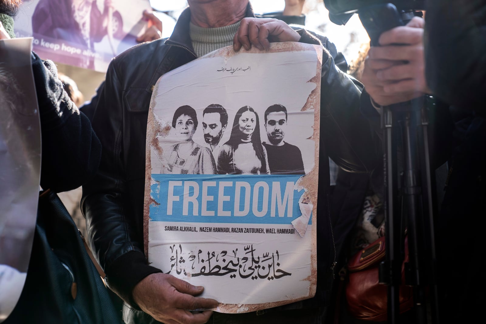 Activists and relatives take part in a protest demanding answers to whereabouts of four activists who disappeared during the war between opposition forces and Asasd regime, in Douma, Syria, Wednesday, Jan. 1, 2025. (AP Photo/Mosa'ab Elshamy)