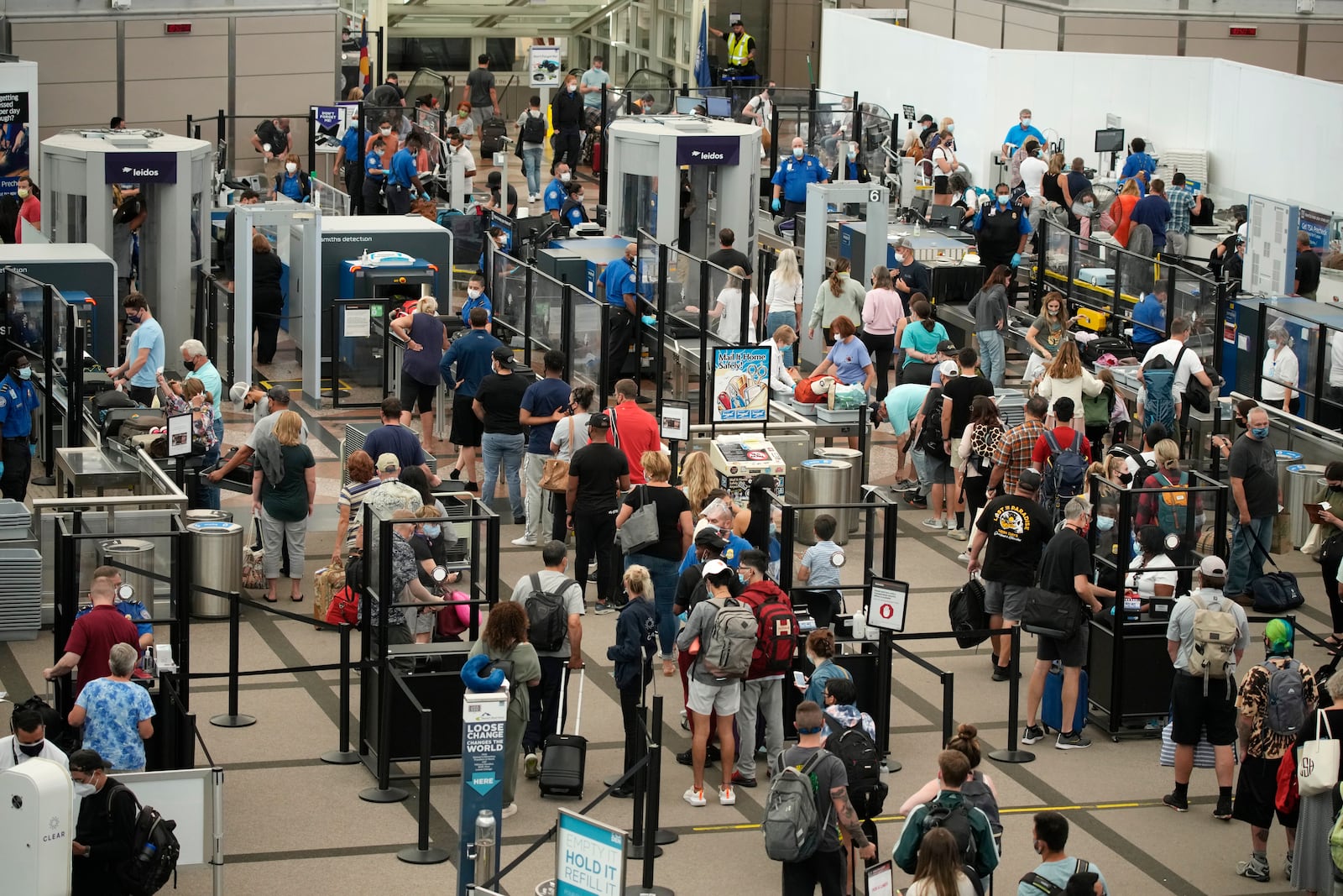 FILE - Travelers wear face coverings in the line for the north security checkpoint in the main terminal of Denver International Airport Tuesday, Aug. 24, 2021, in Denver. (AP Photo/David Zalubowski, File)