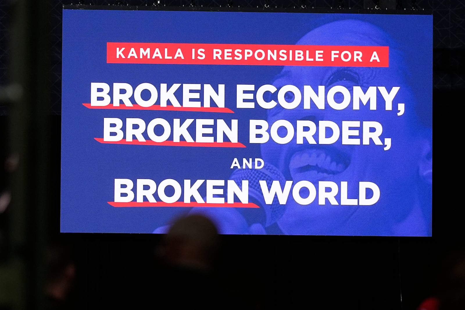 A message about Democratic presidential nominee Vice President Kamala Harris appears on a video screen before Republican presidential nominee former President Donald Trump speaks at a campaign rally at the Gaylord Rockies Resort and Convention Center Friday, Oct. 11, 2024, in Aurora, Colo. (AP Photo/David Zalubowski)