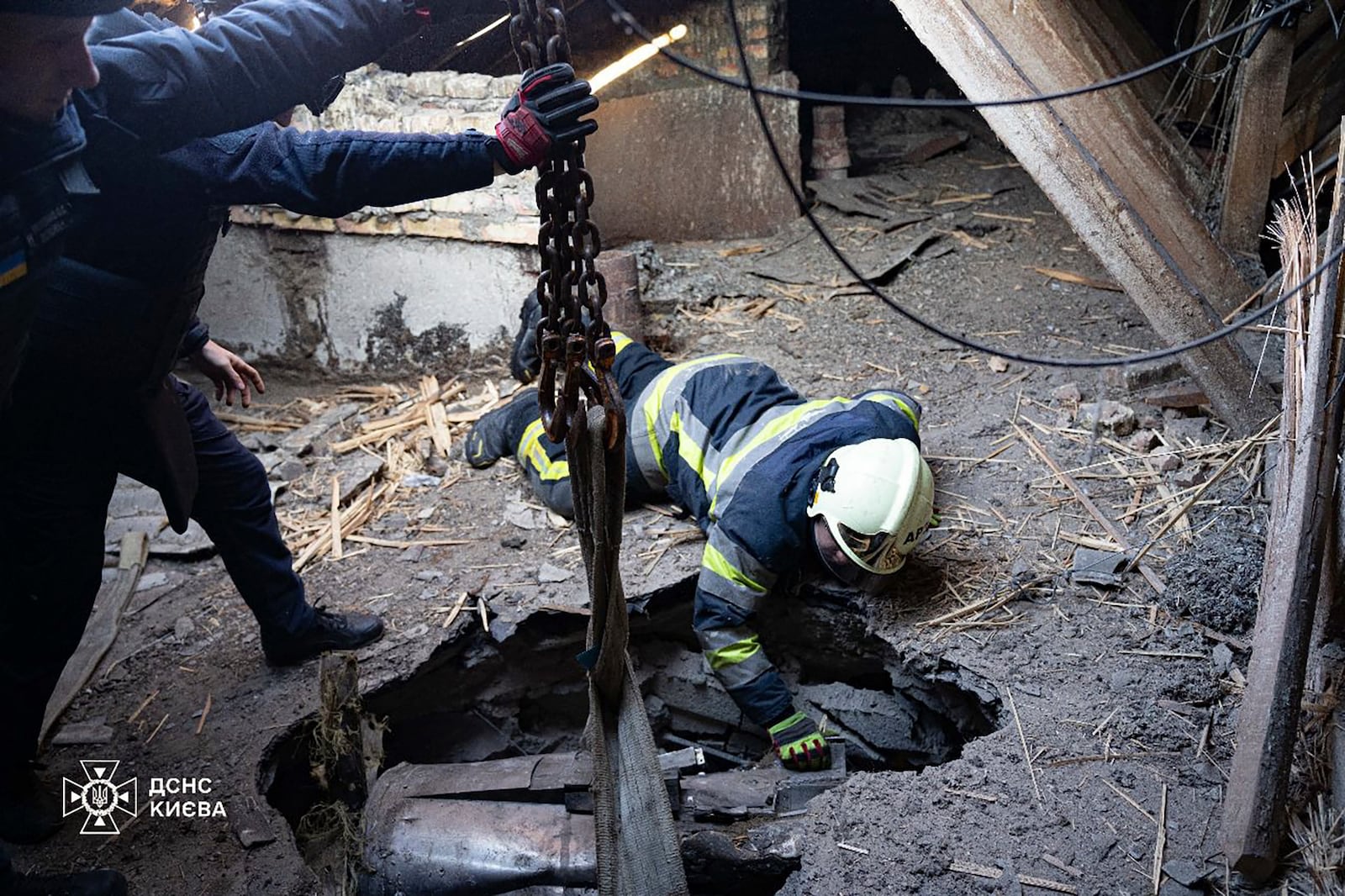 In this photo provided by the Ukrainian Emergency Service, emergency services personnel remove part of a Russian missile that hit an apartment house during massive missile attack in Kyiv, Ukraine, Sunday, Nov. 17, 2024. (Ukrainian Emergency Service via AP)