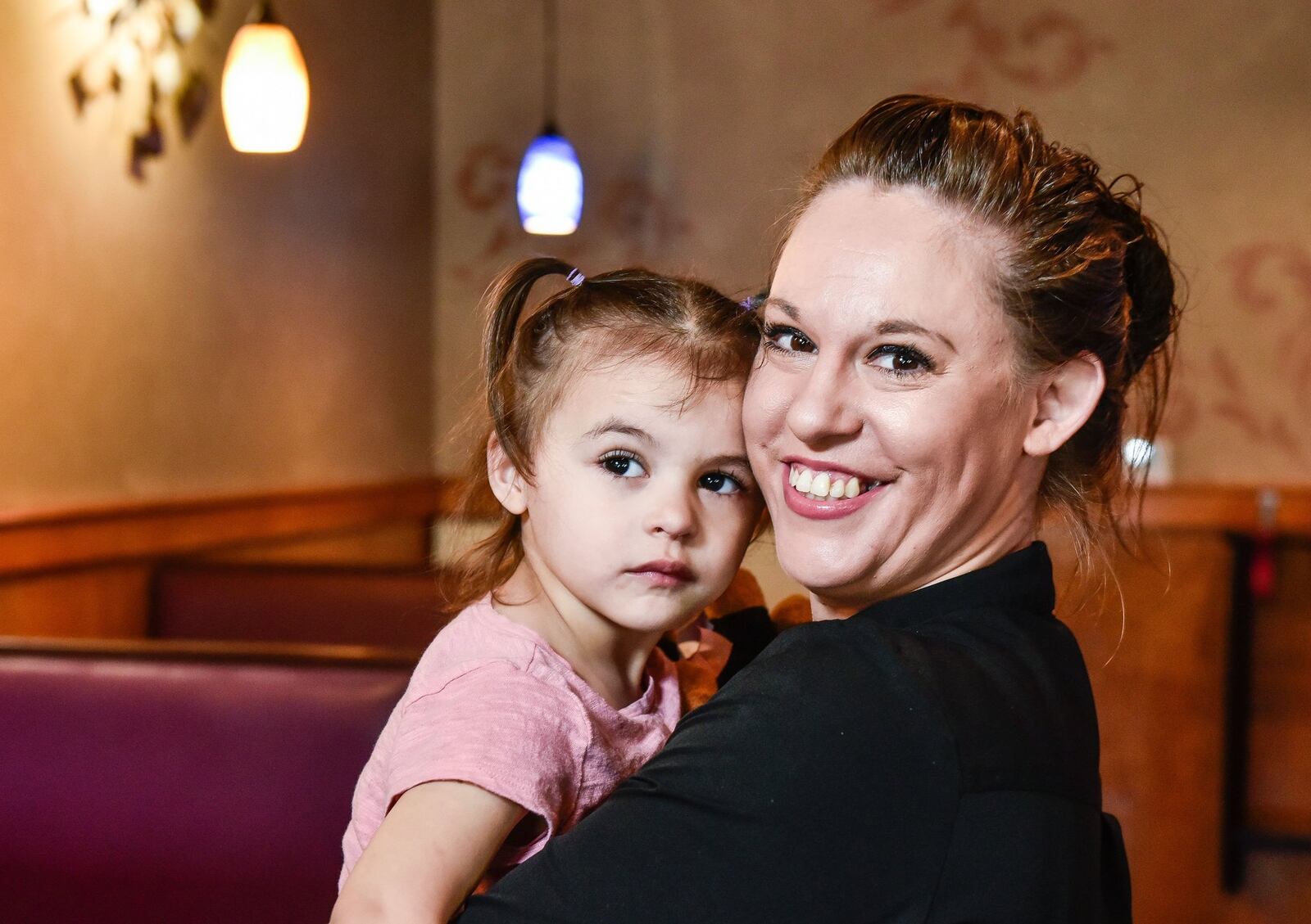 Arlene Williams, 35, a single mother of five, was one of three Middletown mothers who won “Extreme Mom Makeovers” from Berachah Church. Williams, a recovering heroin addict, holds her 2-year-old daughter, Lexi, the youngest of her children. Williams says she has been clean for six years. She works full-time at Spinning Fork Restaurant on Verity Parkway. NICK GRAHAM/STAFF