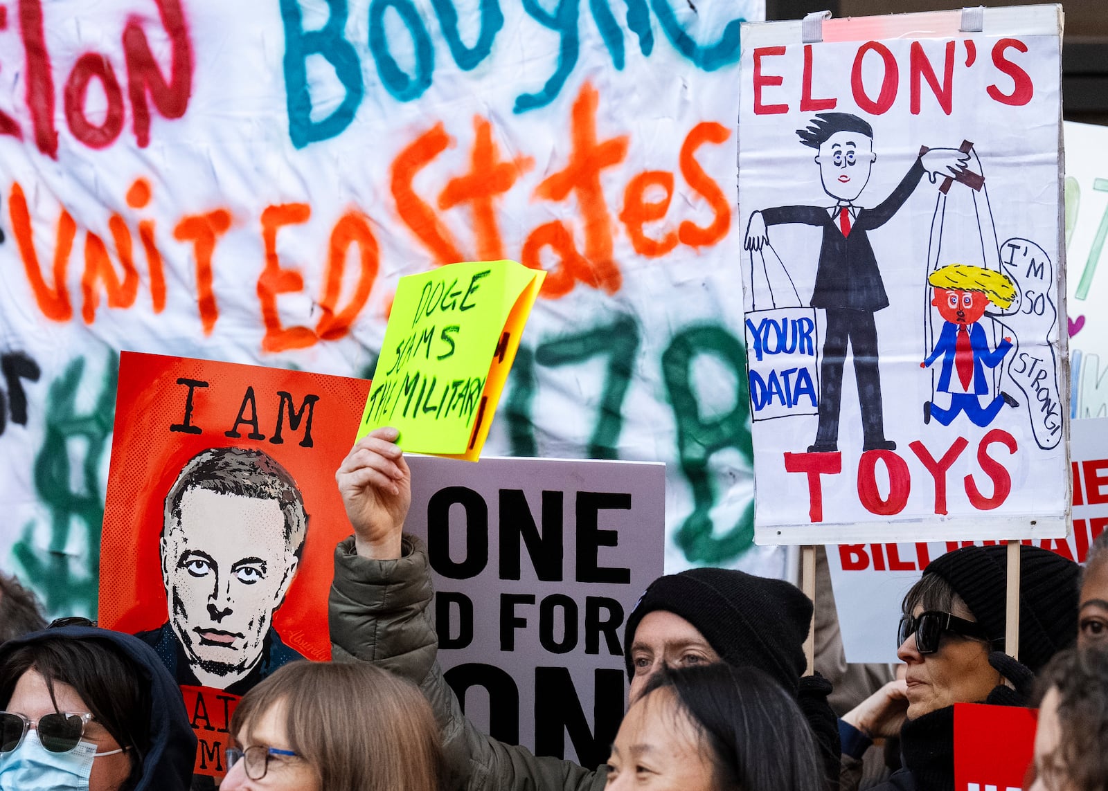 People hold up signs during a protest in support of the Consumer Financial Protection Bureau (CFPB), Monday, Feb. 10, 2025, at CFPB headquarters in Washington. (AP Photo/Jacquelyn Martin)