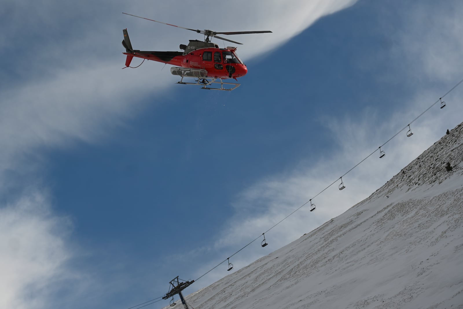 An emergency helicopter flies over the ski lifts at the Astum ski resort in Huesca, Spain, northern Spain on Saturday, Jan 18, 2025, where several people have been injured. (Verónica Lacasa/Europa Press via AP) **SPAIN OUT**