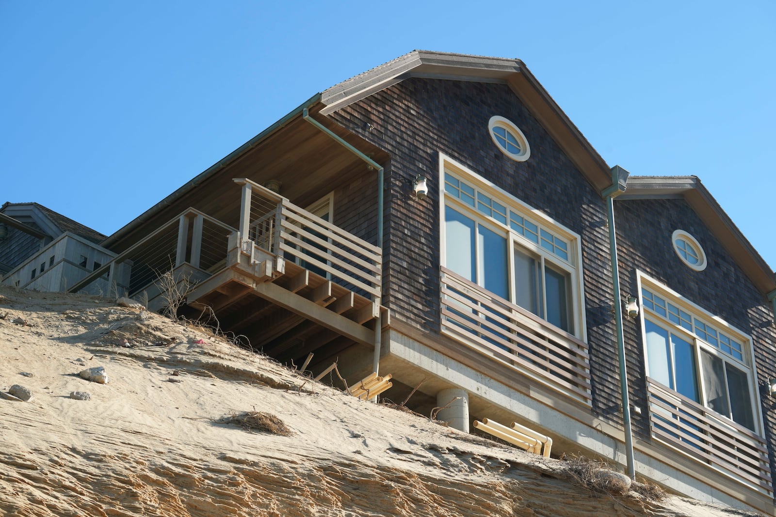 A home sits atop of a sandy bluff in Wellfleet, Mass., Monday, Jan. 27, 2025. (AP Photo/Andre Muggiati)