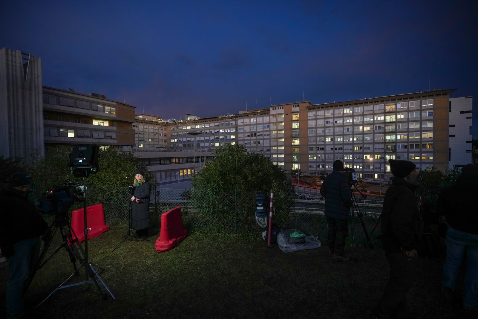 Journalists wait outside the Agostino Gemelli Polyclinic in Rome, Saturday, Feb. 15, 2025, where Pope Francis was hospitalized Friday after a weeklong bout of bronchitis worsened and is receiving drug therapy for a respiratory tract infection. (AP Photo/Alessandra Tarantino)