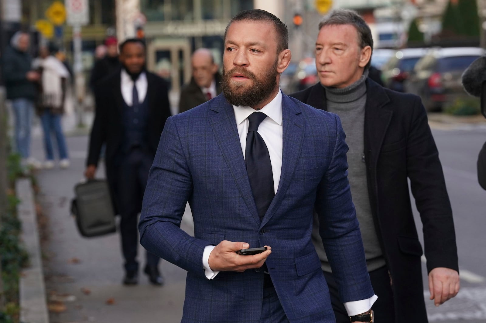 Mixed martial arts fighter Conor McGregor, front, and his father Tony, right, outside the High Court in Dublin, Ireland, Thursday, Nov. 21, 2024. (Brian Lawless/PA via AP)