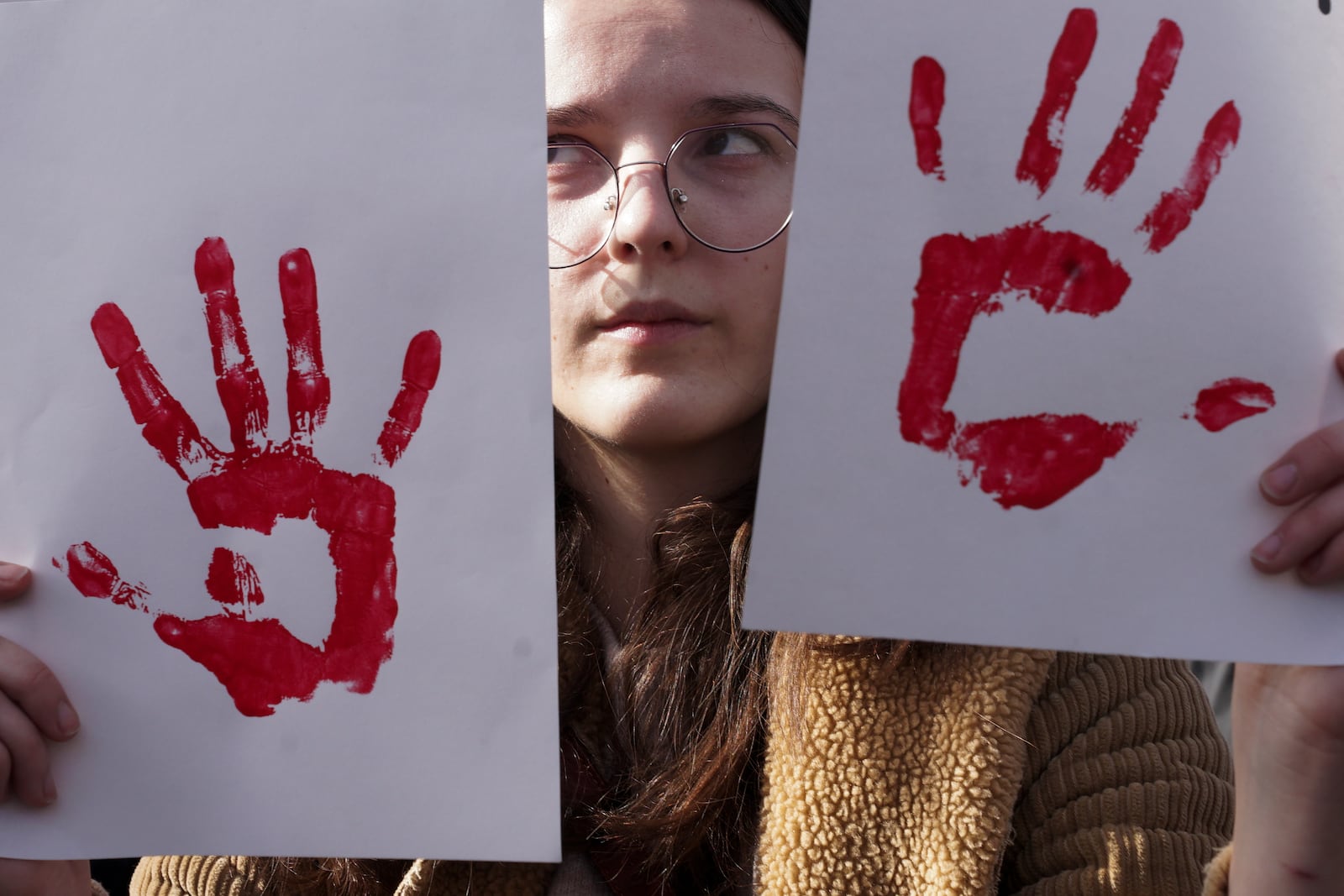 A young woman holds banners during a protest to support Serbian students, in the Bosnian town of Banja Luka, 240 kms northwest of Sarajevo, Friday, Jan. 31, 2025. (AP Photo/Radivoje Pavicic)