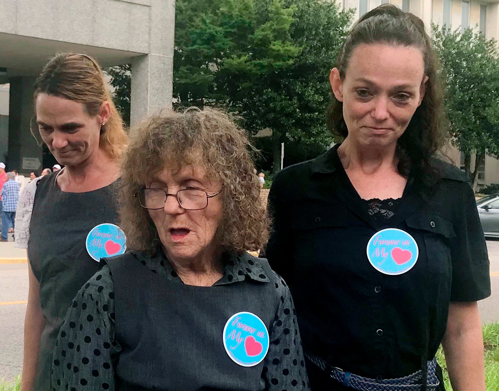 Frankie Mason, center, the mother of murder victim Lisa Ann Millican, speaks with reporters after Alabama's parole board refused to release convicted killer Judith Ann Neeley during a hearing in Montgomery, Ala., on Wednesday, May 23, 2018. The victim's younger sisters, Tina Millican, right, and Judy Bradley, left, stand beside her.