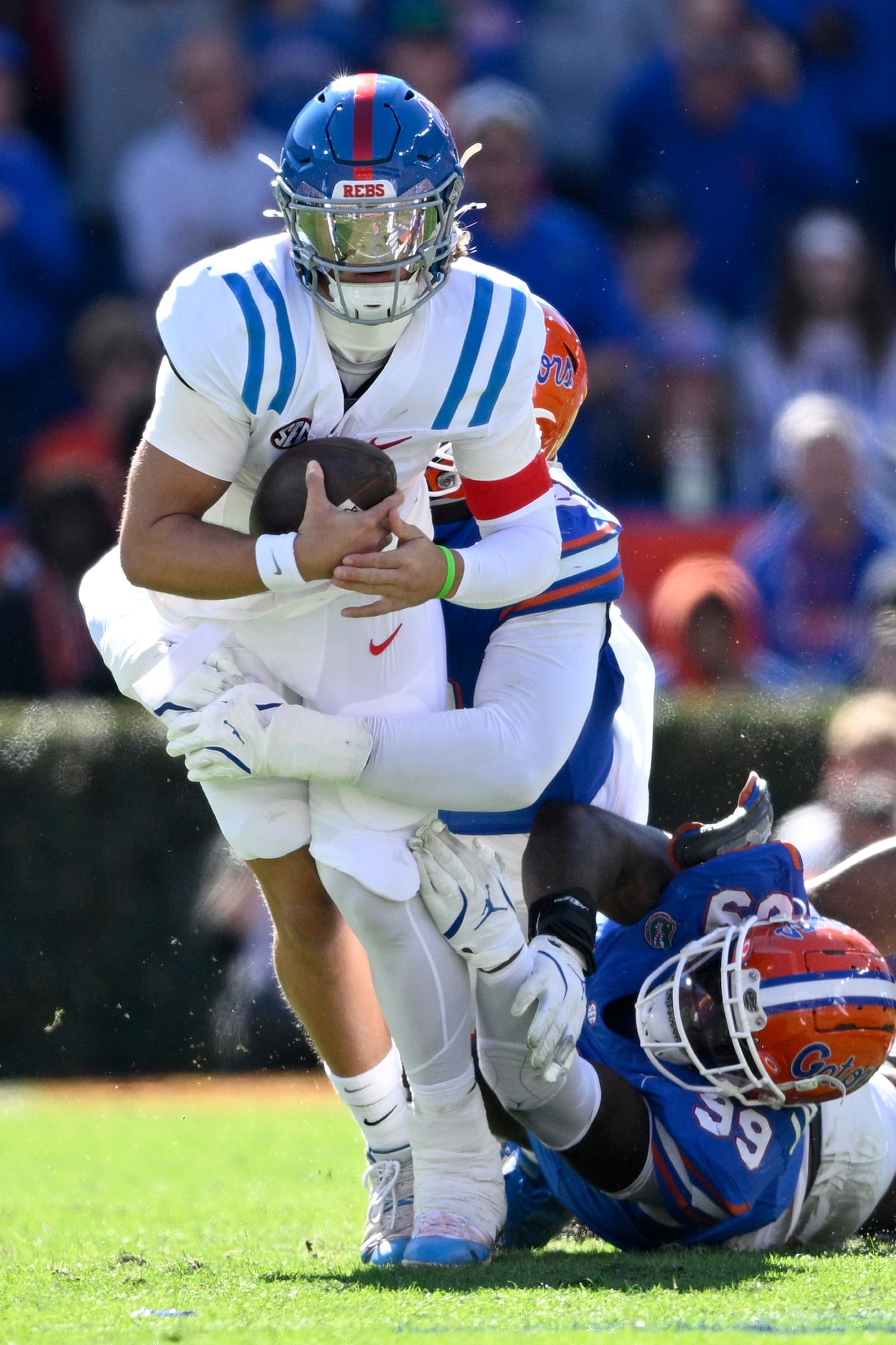 Mississippi quarterback Jaxson Dart, front, is sacked by Florida defensive lineman Caleb Banks, center, and defensive lineman Cam Jackson (99) during the first half of an NCAA college football game, Saturday, Nov. 23, 2024, in Gainesville, Fla. (AP Photo/Phelan M. Ebenhack)