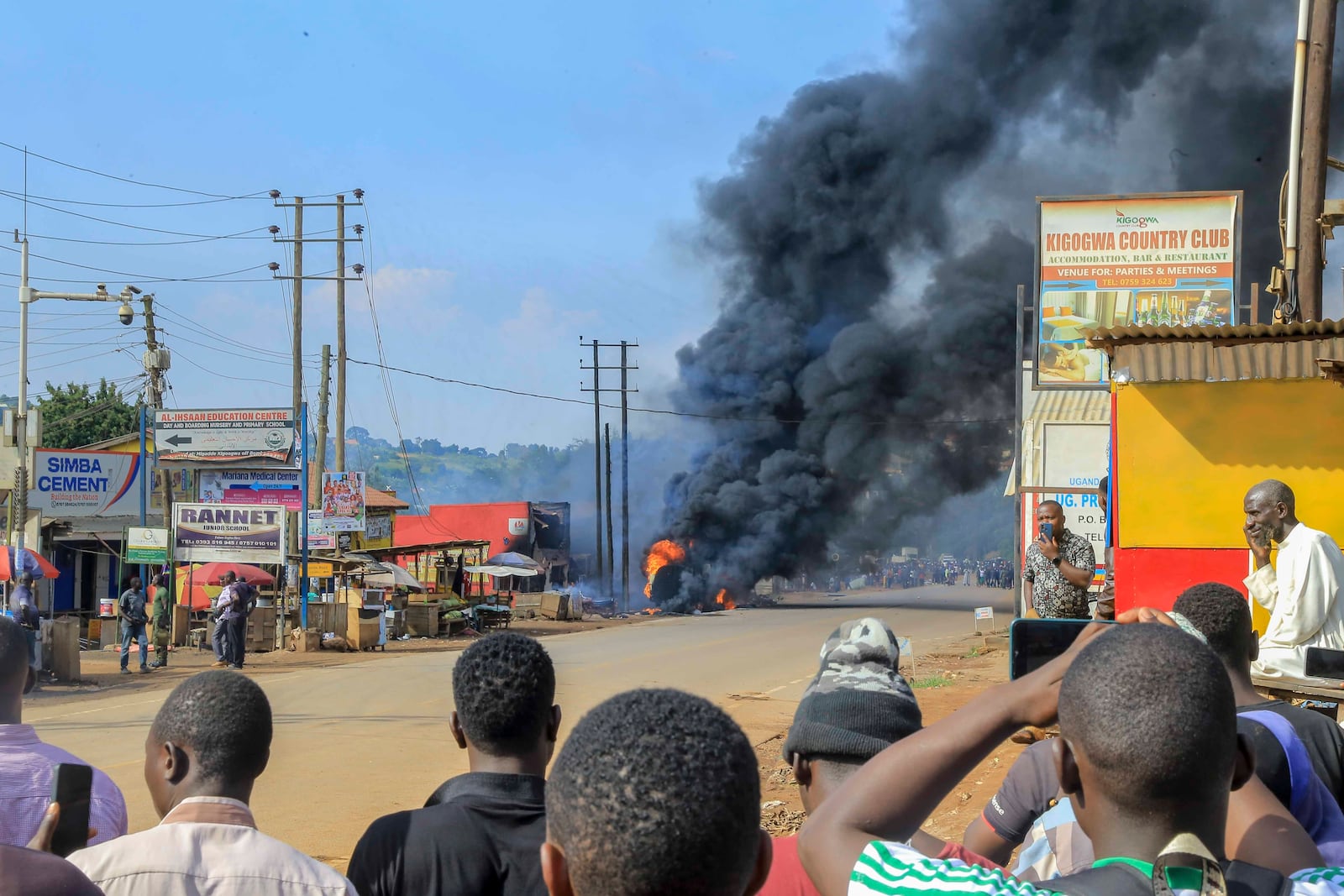 People gather near the site where a fuel truck exploded, next to a highway on the outskirts of Kampala, Uganda, Tuesday, Oct. 22, 2024. (AP Photo)