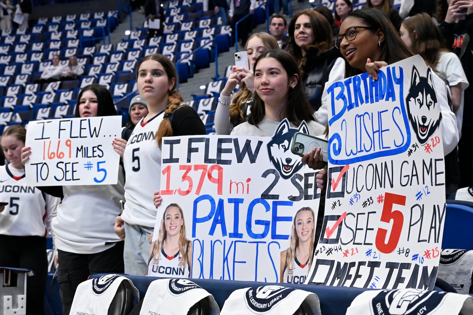 Fans of UConn guard Paige Bueckers watch her warm up before an NCAA college basketball game against Southern California, Saturday, Dec. 21, 2024, in Hartford, Conn. (AP Photo/Jessica Hill)