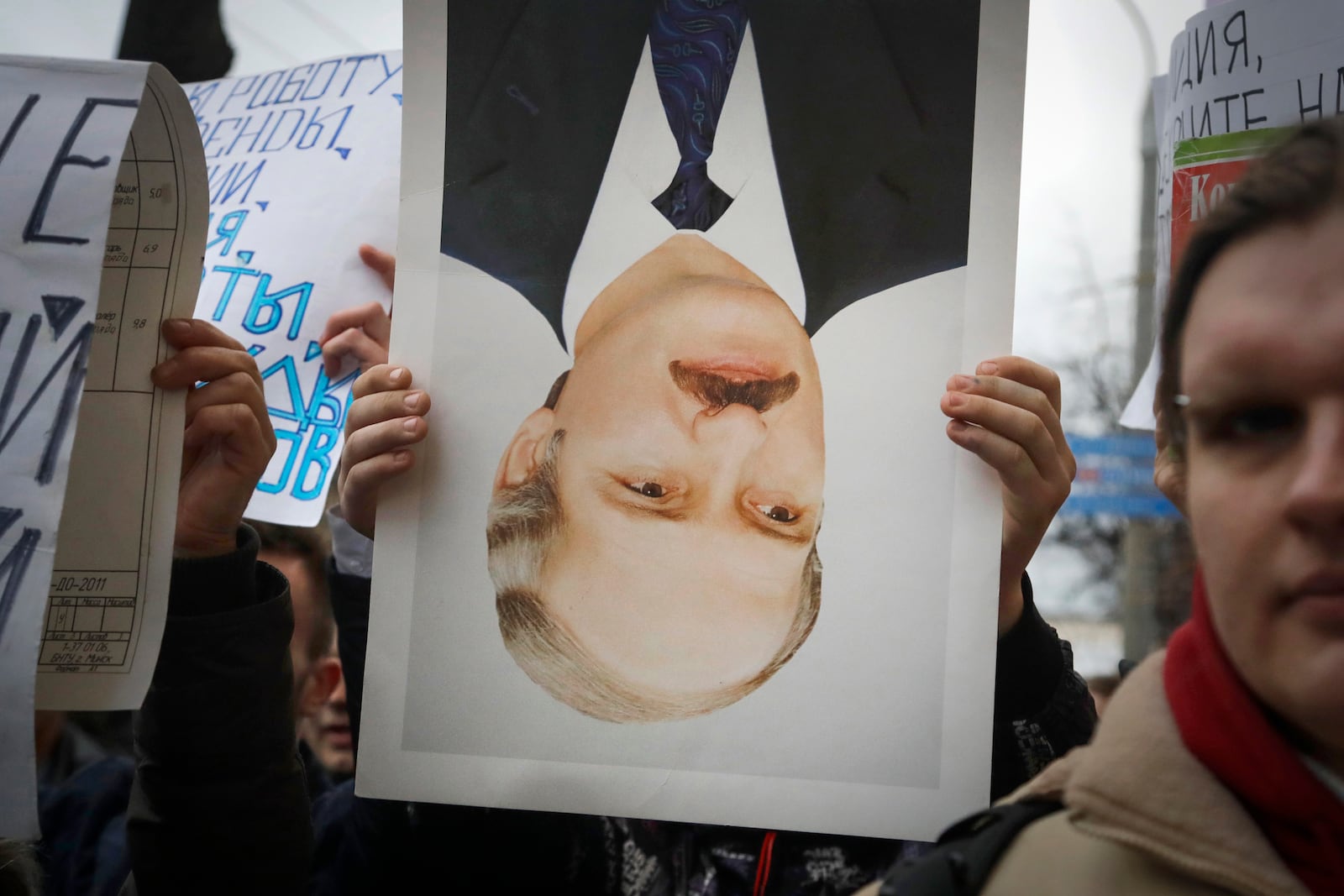 FILE - A protester holds an overturned portrait of President Alexander Lukashenko during a rally in Minsk, Belarus, on March 15, 2017. (AP Photo, File)