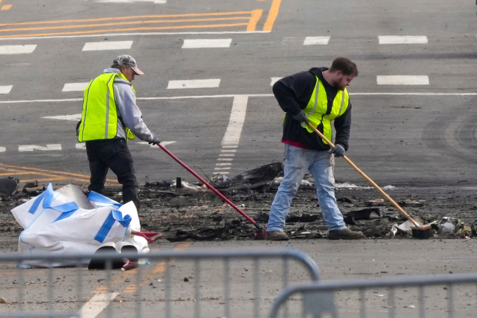 Workers collect debris in the aftermath of a fatal small plane crashed in Philadelphia, Monday, Feb. 3, 2025. (AP Photo/Matt Rourke)