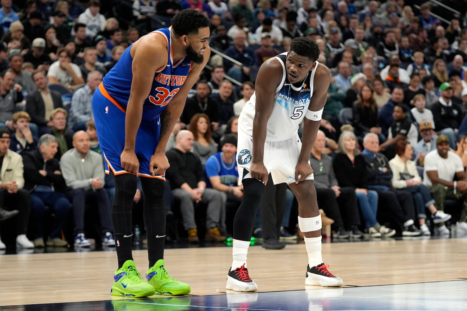 New York Knicks center Karl-Anthony Towns (32) and Minnesota Timberwolves guard Anthony Edwards (5) talk during the first half of an NBA basketball game, Thursday, Dec. 19, 2024, in Minneapolis. (AP Photo/Abbie Parr)