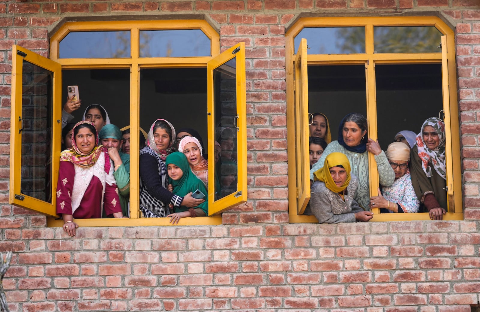 Relatives and neighbors watch the funeral of Kashmiri doctor Shahnawaz who was among those killed when gunmen fired at people working on a strategic tunnel project in Indian-controlled Kashmir, at Nadigam village, southwest of Srinagar, Monday, Oct. 21, 2024. (AP Photo/Mukhtar Khan)