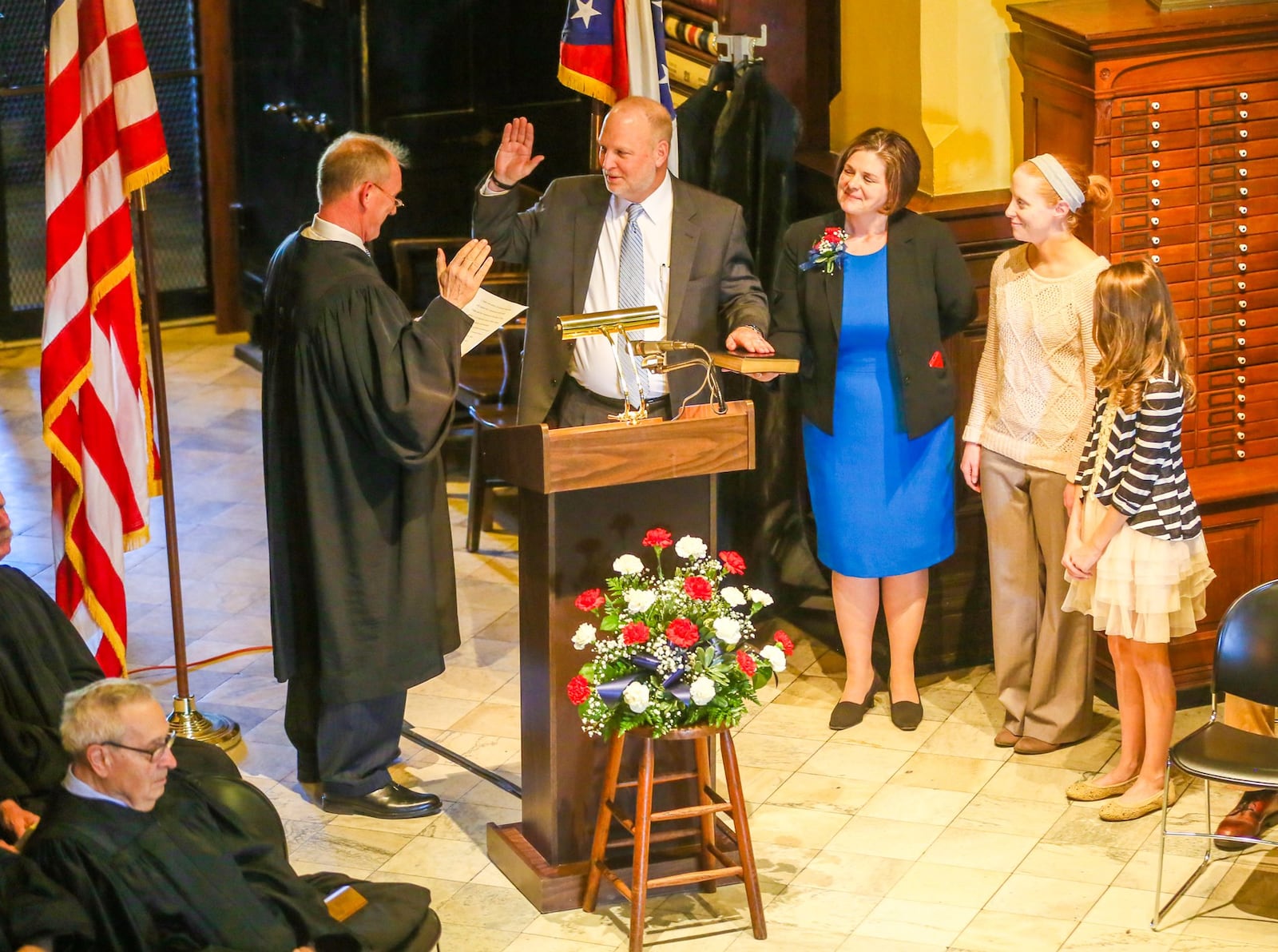 Greg Howard, accompanied by his wife Melynda Cook Howard, and daughters Allie Howard and Lorena Reich, is sworn in Feb. 17 as the new Butler County Common Pleas judge. GREG LYNCH / STAFF