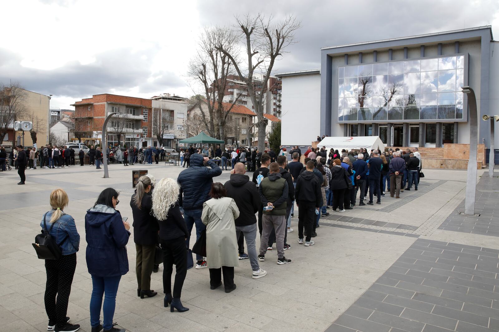 People wait in line to write condolence messages for the victims of a massive nightclub fire in the town of Kocani, North Macedonia, Monday, March 17, 2025. (AP Photo/Boris Grdanoski)