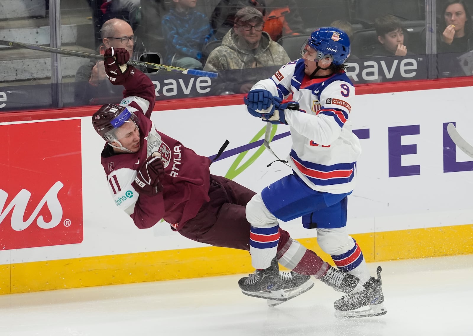 United States forward Ryan Leonard (9) collides with Latvia forward Dmitrijs Dilevka (11) during the second period of a IIHF World Junior Hockey Championship tournament game, Saturday, Dec.28, 2024 in Ottawa, Ontario. (Adrian Wyld/The Canadian Press via AP)