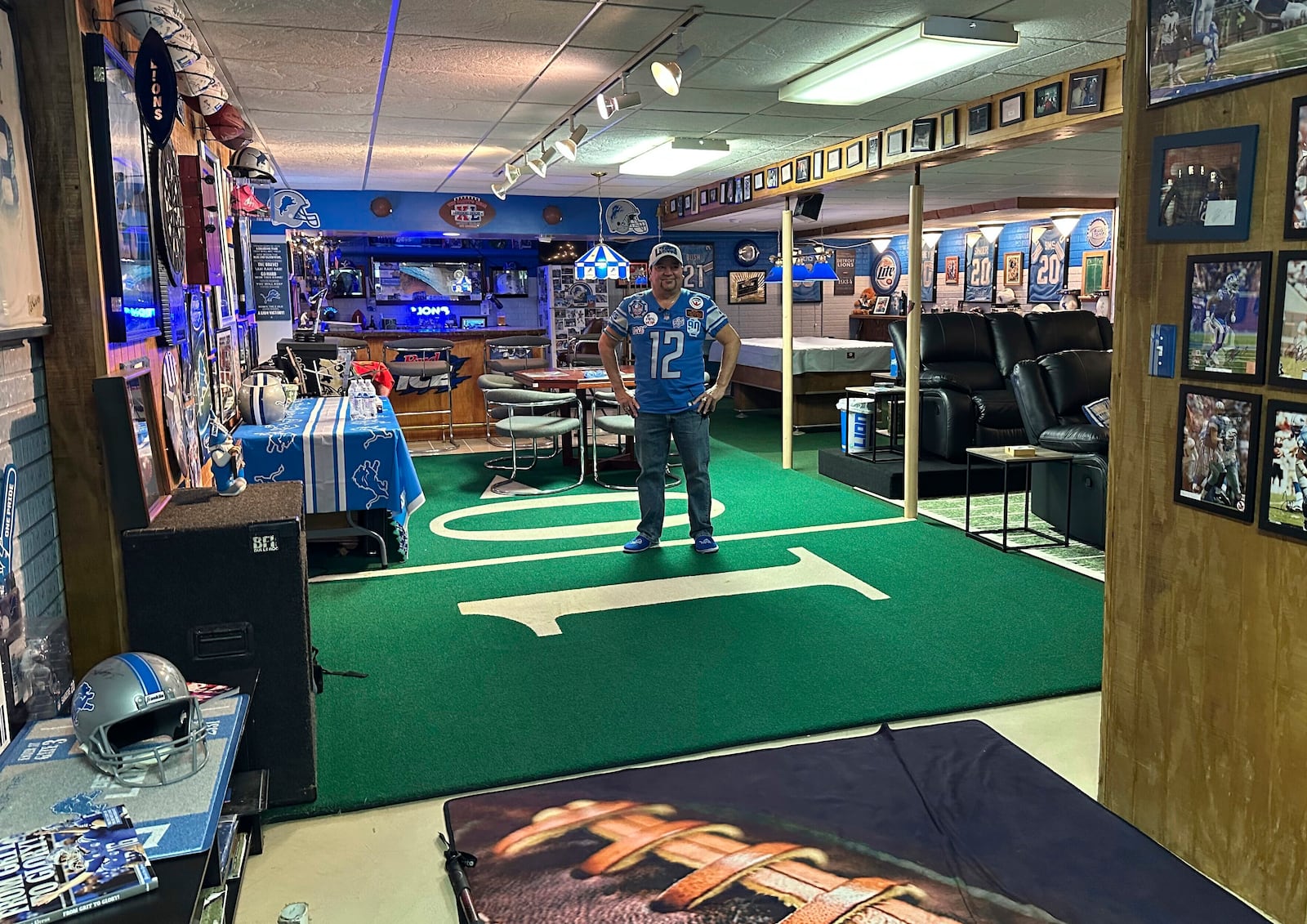 Detroit Lions NFL football fan Rob Gonzales stands on Pontiac Silverdome turf in the basement of his home Thursday, Jan. 16, 2025, in Frenchtown Township, Mich. (AP Photo/Mike Householder)