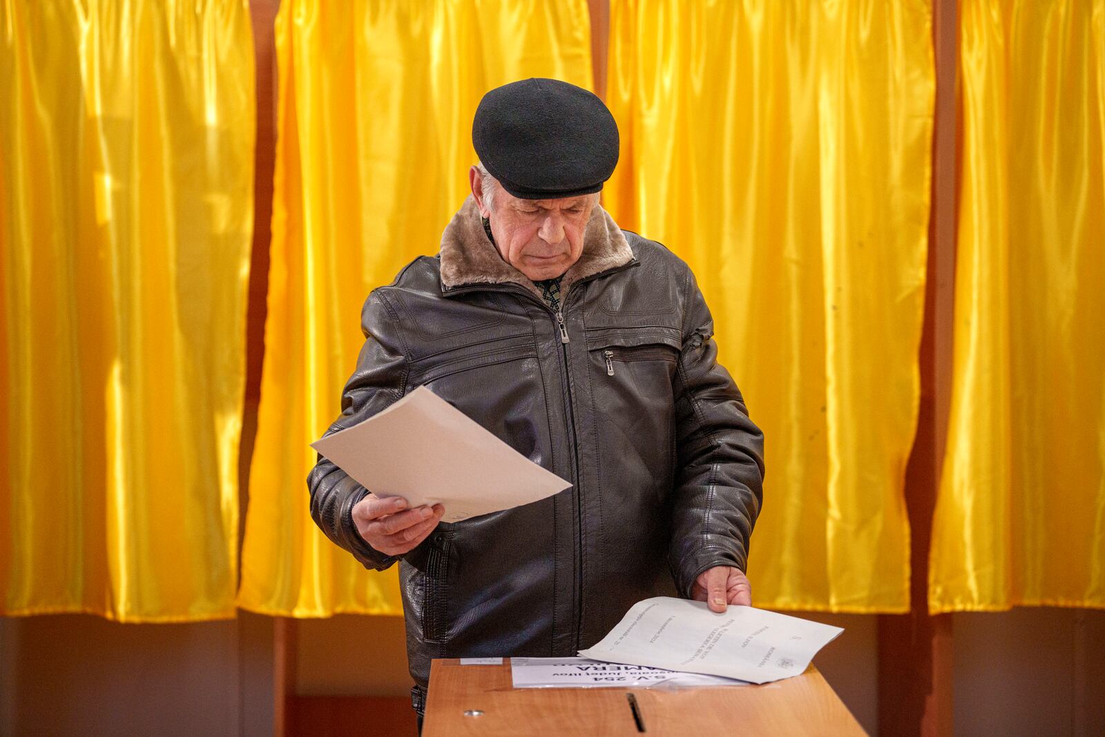 A man prepares to cast his vote in the country's parliamentary elections, in Mogosoaia, Romania, Sunday, Dec. 1, 2024. (AP Photo/Andreea Alexandru)