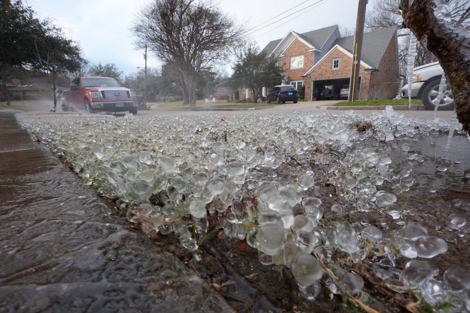 Cold temperatures and a lawn sprinkler create ice on grass ahead of a winter storm expected to hit the North Texas region later tomorrow Wednesday, Jan. 8, 2025, in Richardson, Texas. (AP Photo/LM Otero)